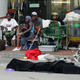 The body of a man, covered by a blanket, lies in the street as members of his family, driven from their homes by Hurricane Katrina, wait outside the Ernest N. Morial Convention Center in downtown New Orleans in 2005 in hopes of being evacuated from the flooded-out city. The man was allegedly shot several times by police officers after he tried to flag down their car. (Corey Sipkin/NY Daily News Archive via Getty Images)
